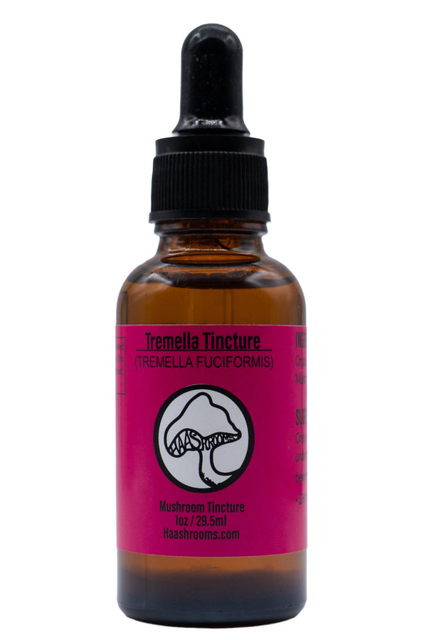 A dropper bottle labeled Tremella Tincture with a pink and white label, containing a mushroom extract. The bottle is amber-colored with a black dropper.